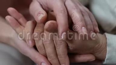 年轻女子抚摸着养老者的手，照顾着年迈的父母，同情着